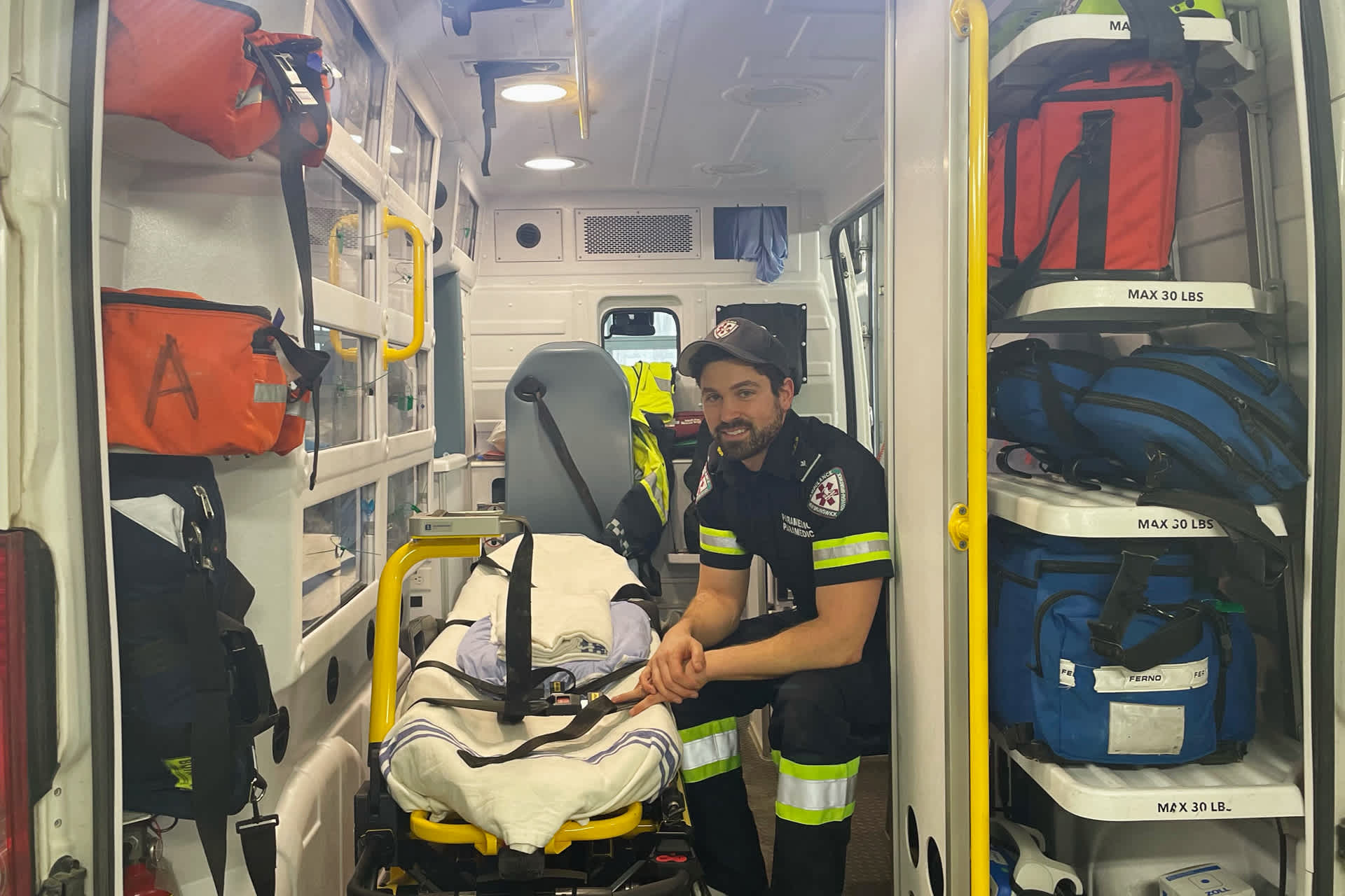 A paramedic sitting in the back of an ambulance