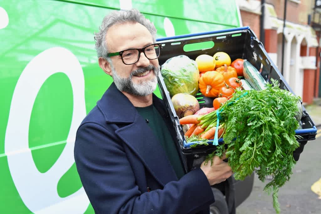 Massimo Bottura holding a basket of fresh vegetables