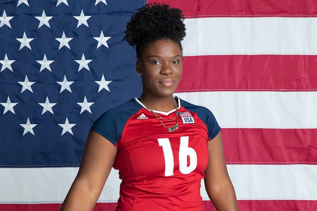 Nicki Nieves wears a number 16 jersey and stands in front of an American flag