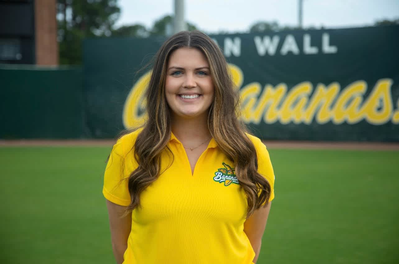 image of white woman in yellow polo shirt with Savannah Bananas team logo