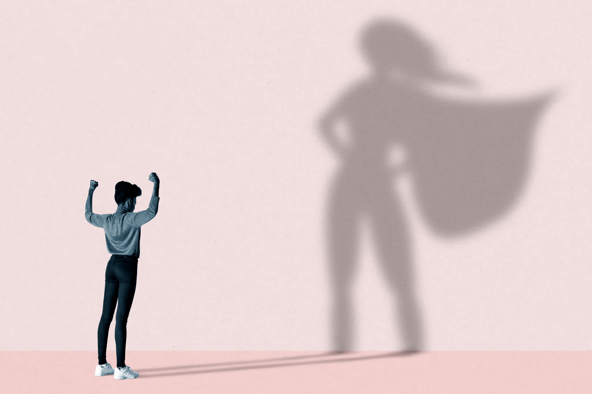 Graphic: a girl posing like a superhero casting a large heroic shadow