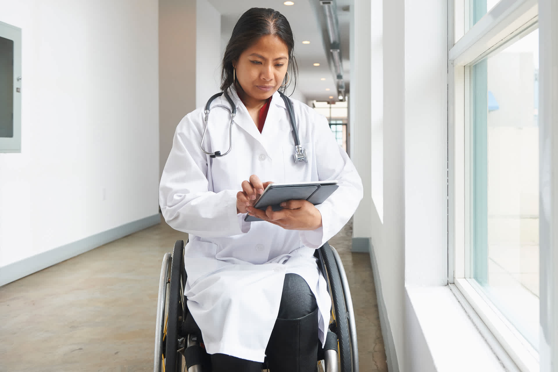 A doctor in a wheelchair working on a tablet
