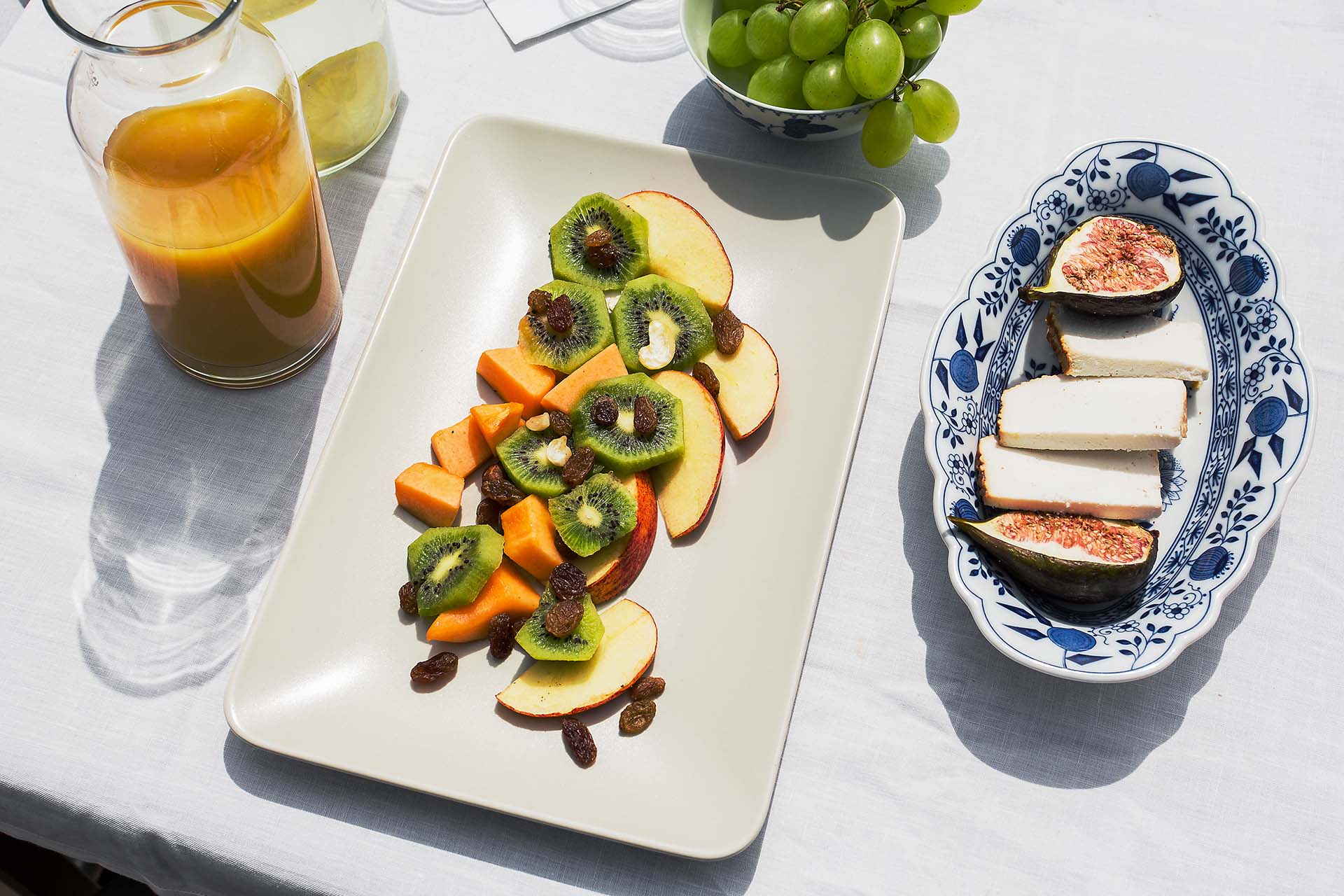 Fruits, juice and cheese on the breakfast table
