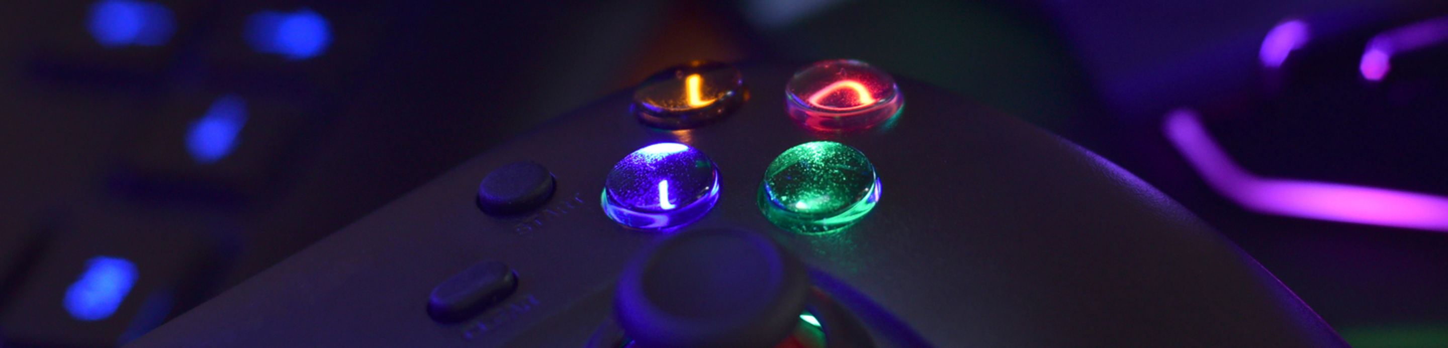 A gaming laptop setup-up glows in a dark playroom.