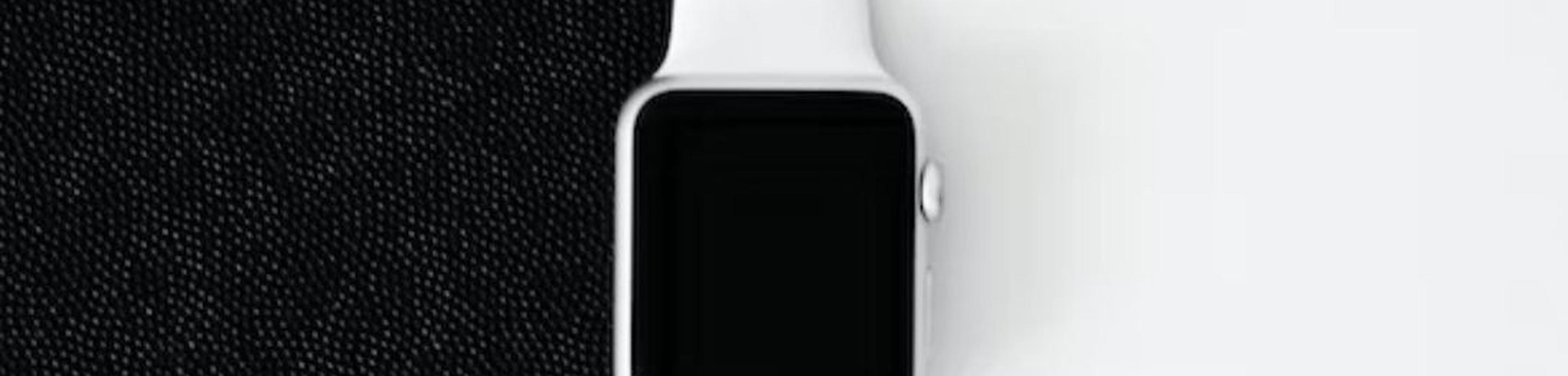 Une Apple Watch sur un fond moitié noir, moitié blanc.