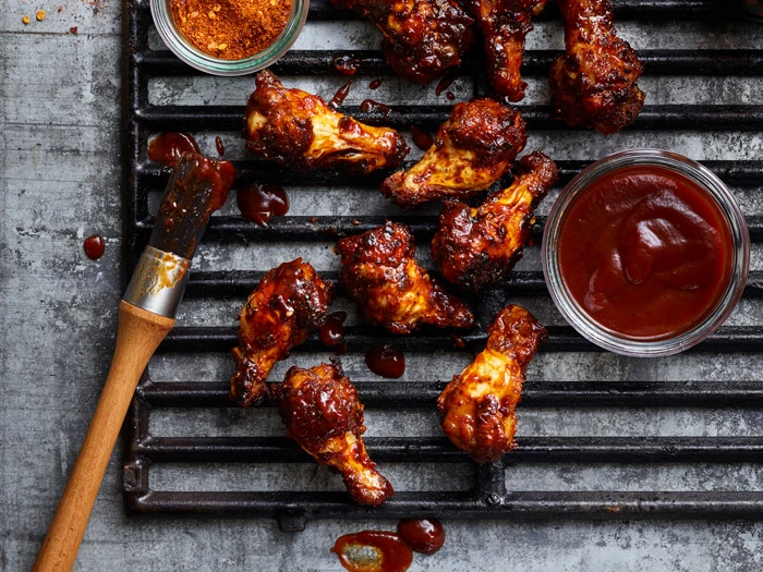 chicken wings on grill with sauces