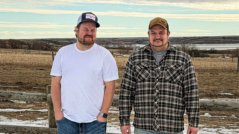 Two farm operators standing on pastureland near Lucky Lake, Saskatchewan.
