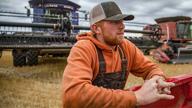 Un agriculteur devant de l’équipement agricole