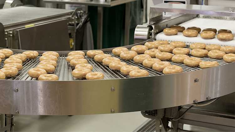 Beignes glacés sur une chaîne de production.