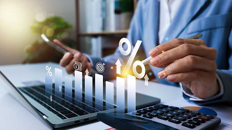 A bar chart showing rising interest rates overlayed on a picture of a computer.