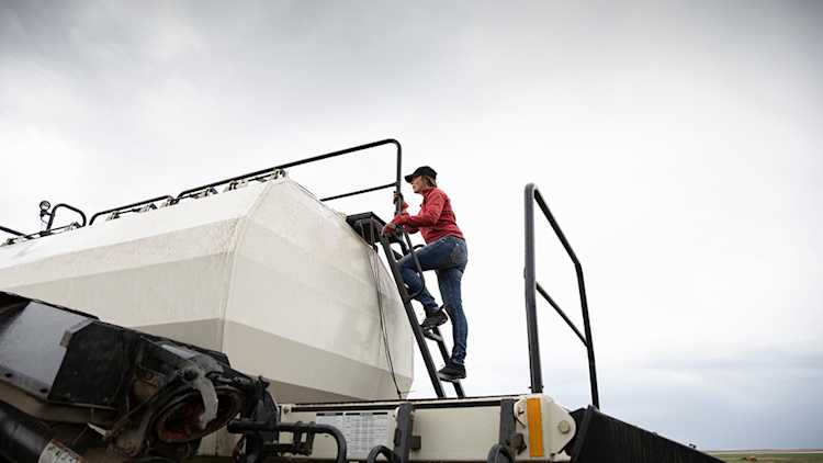 Woman climbing up tank on an air drill