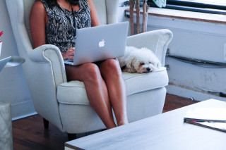 women on chair with dog and laptop
