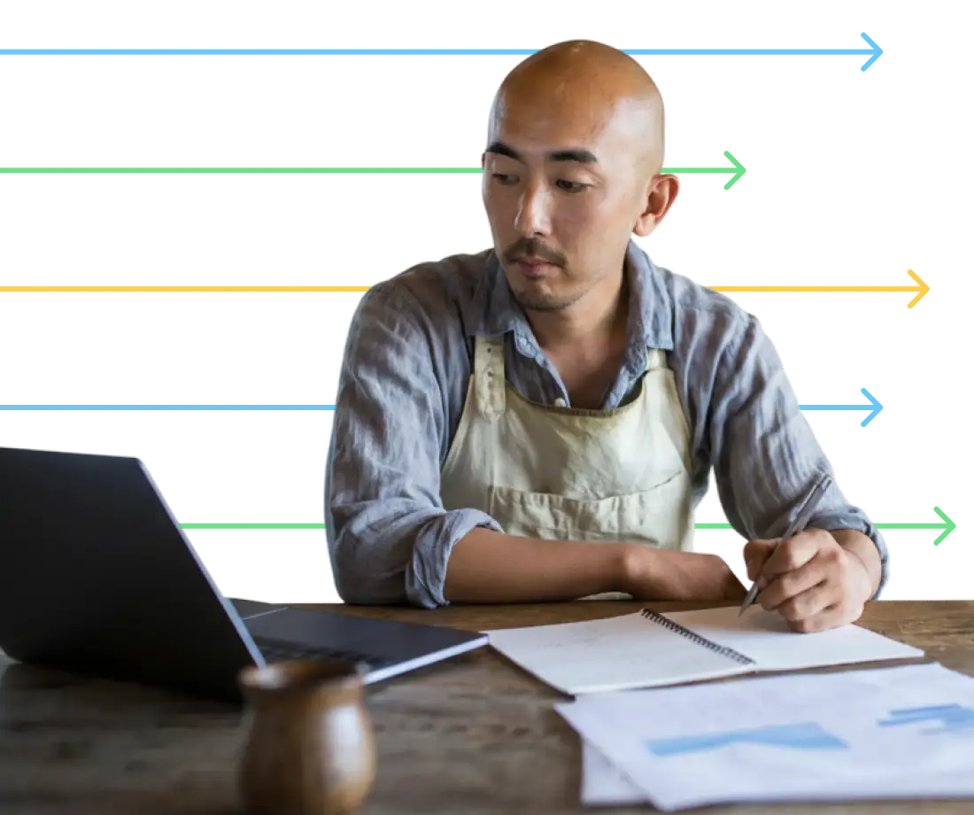 Blog - Hero - Person evaluating PEOs using pen and paper while looking at a laptop 
