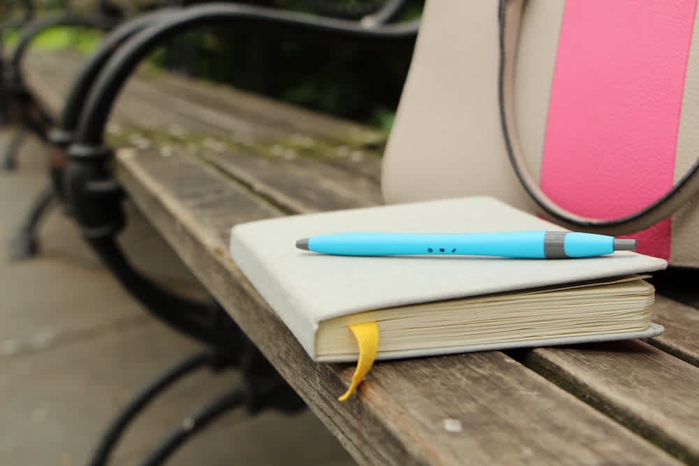 Blog - Hero - Notebook with Justworks pen on park bench