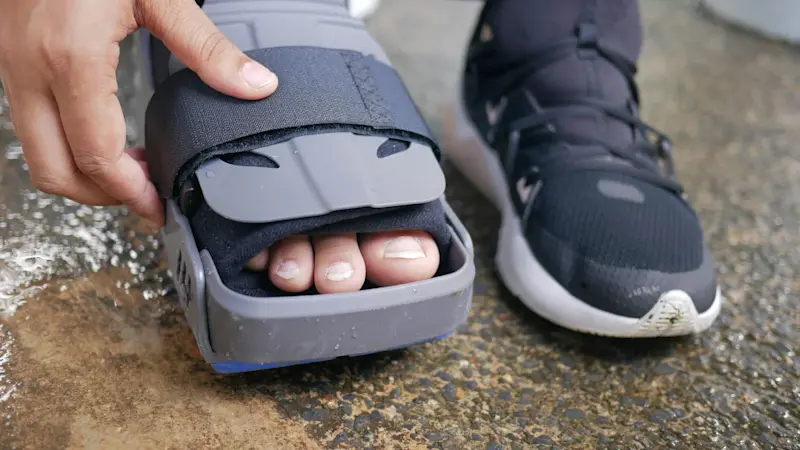 An orthotic patient adjusting their pneumatic walker boot