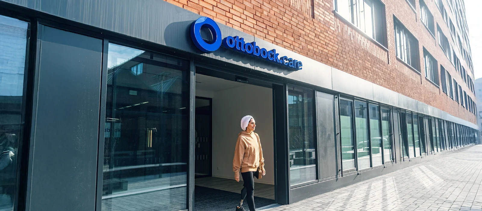 Un usuario de pie protésico saliendo de un centro de tratamiento ortoprotésico Ottobock.care