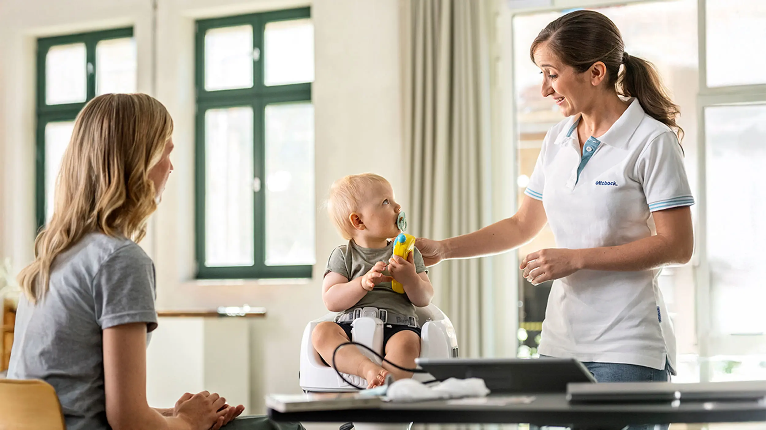 A parent and their child being consulted by a Certified Orthotist for their eligibility for a cranial remolding helmet