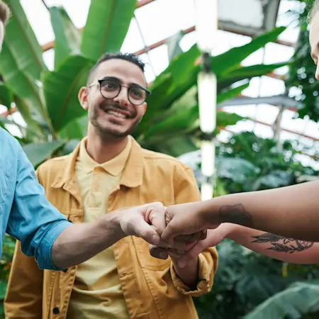 A group of individuals bumping fists in a circle