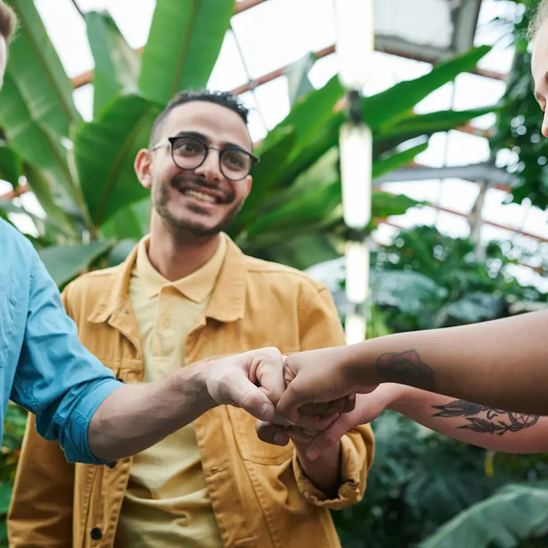 A group of individuals bumping fists in a circle