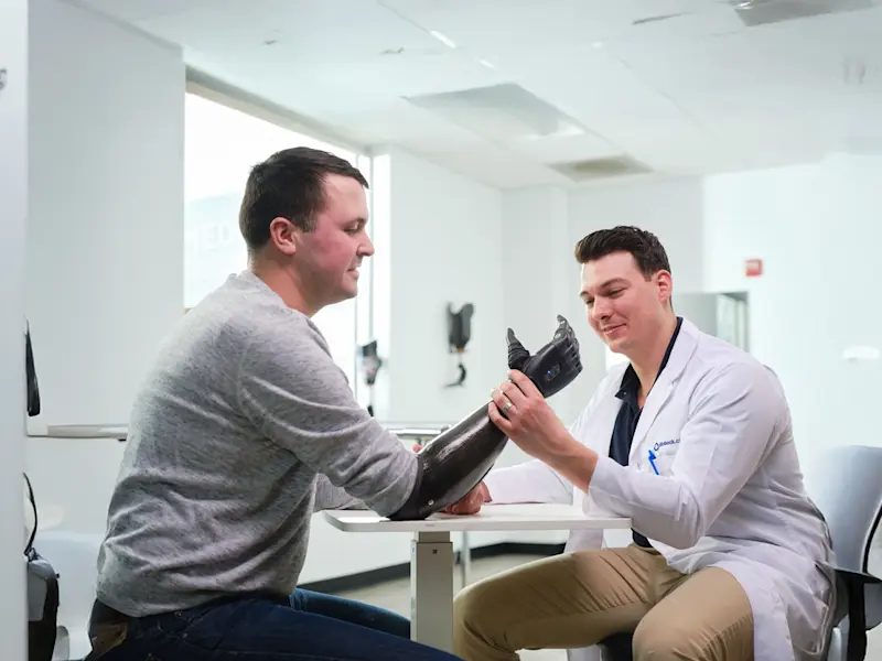 A practitioner meeting with an upper limb amputee at an orthotic and prosthetic clinic