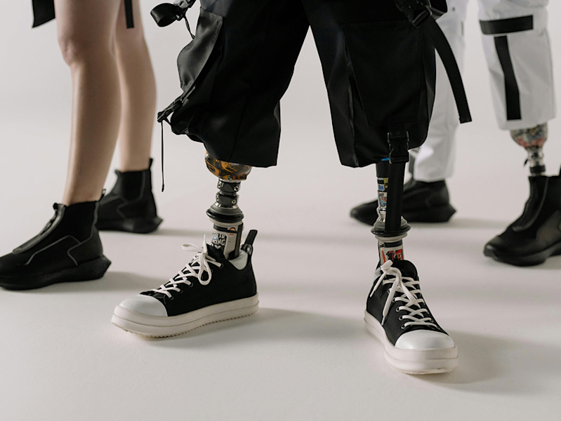 A close up shot from the knees down showcasing two prosthetic leg users