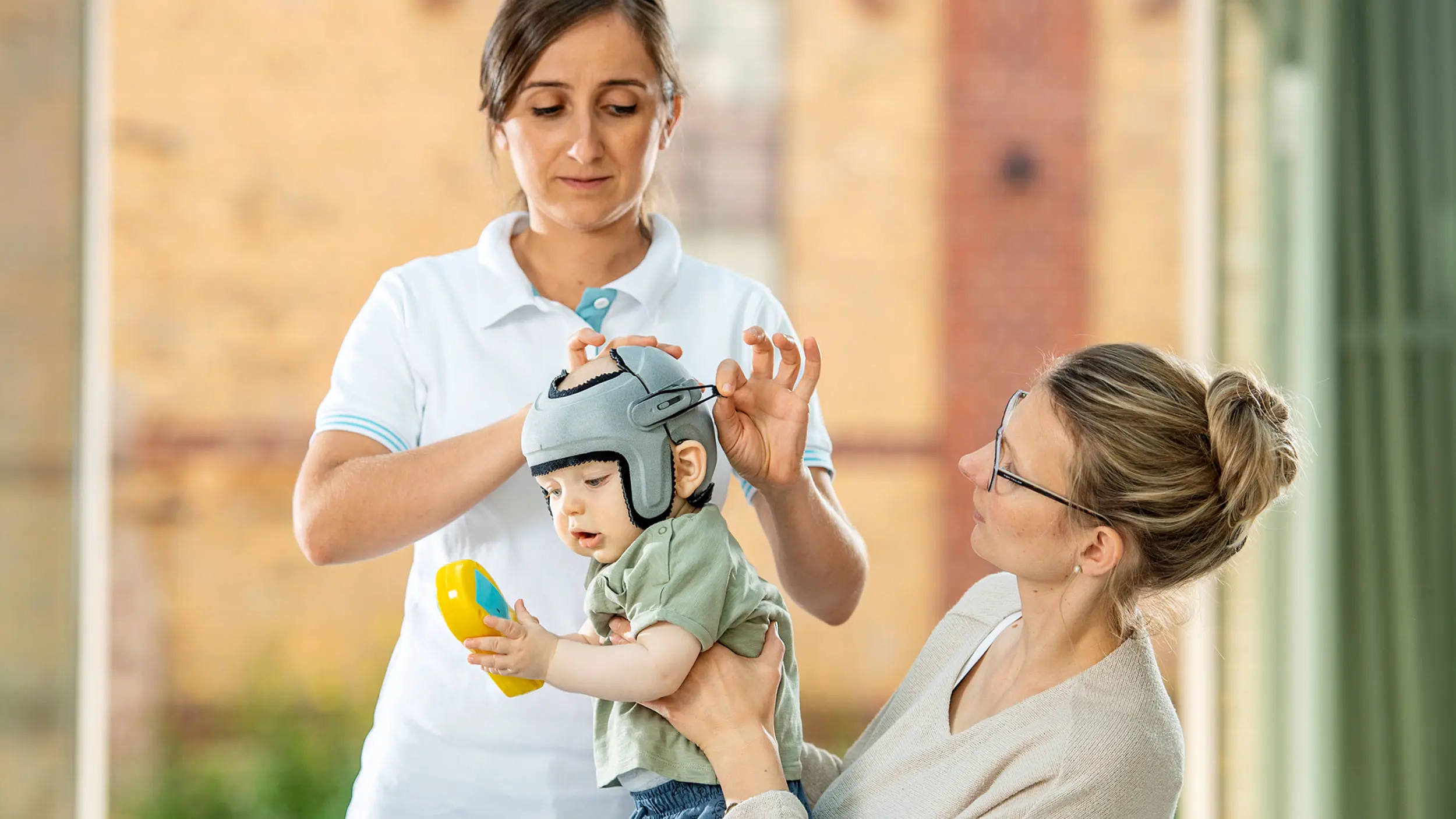 A Certified Orthotist adjusting the MyCRO band helmet by Ottobock on an infant