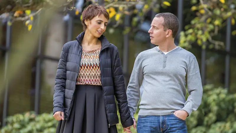 Una paziente con l'ortesi FreeWalk sulla gamba sinistra passeggia mano nella mano con il compagno