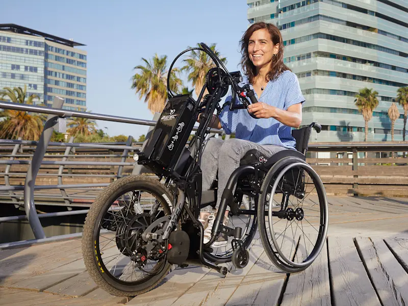 Una donna prova il dispositivo di trazione ibrido Batec in riva al mare