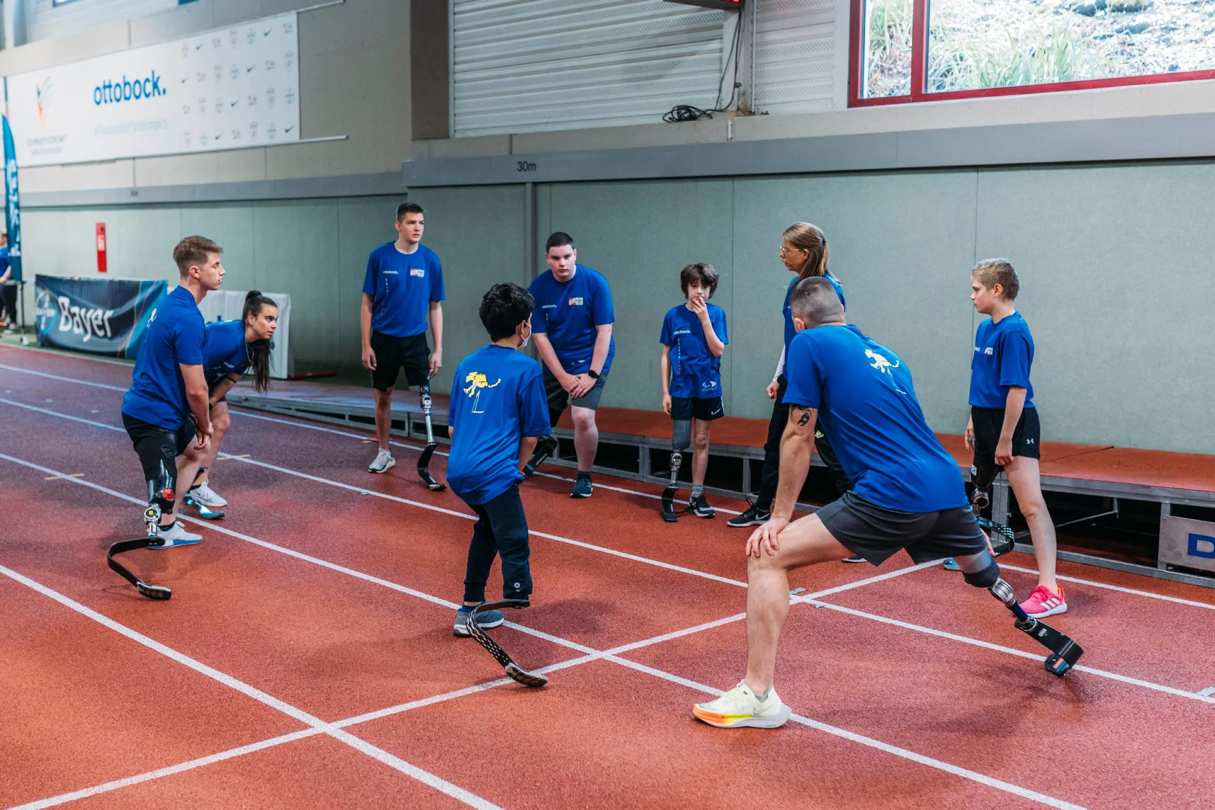 A group of kid prosthetic users huddling before a physical activity