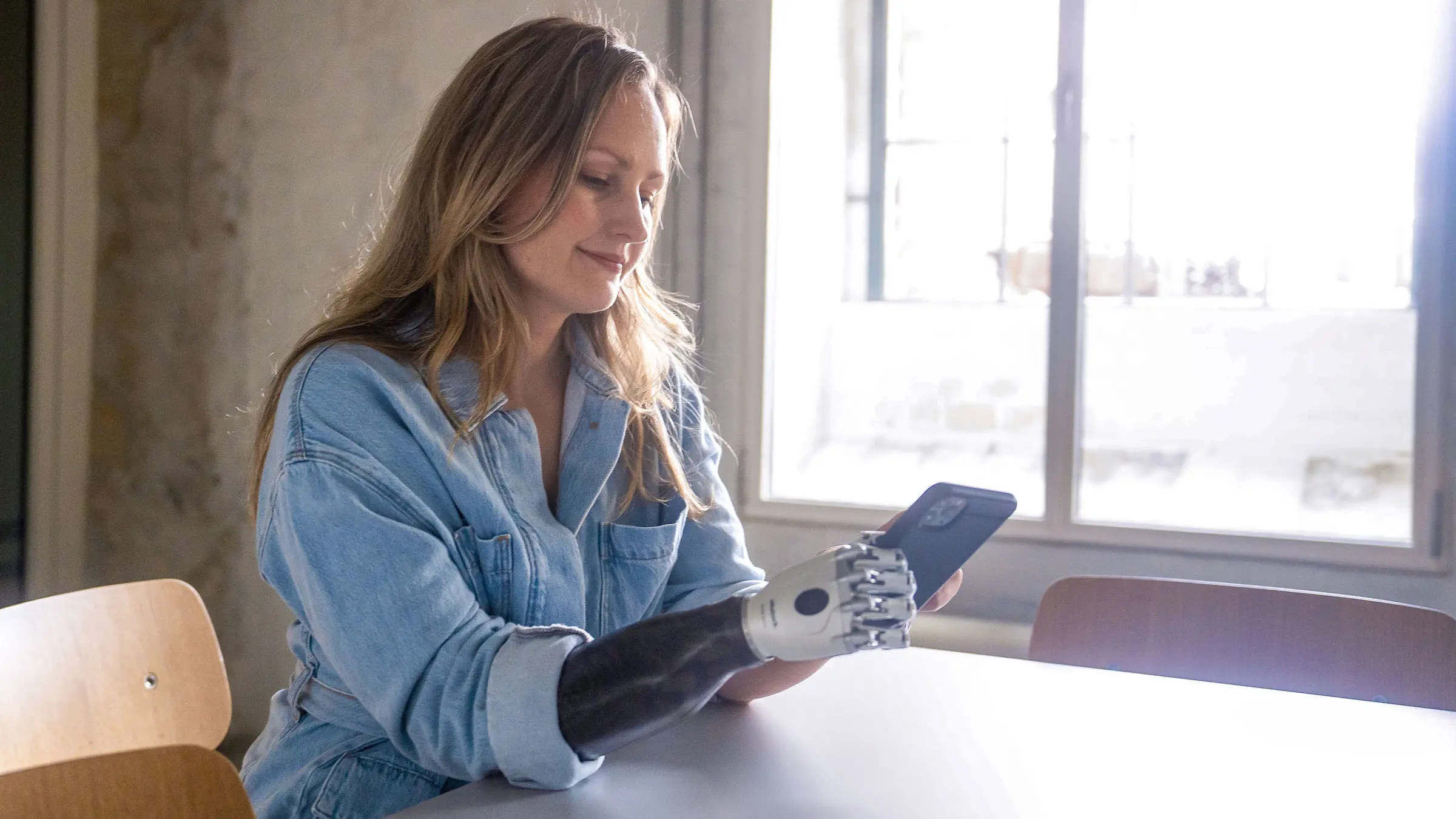 An upper limb prosthetic user browsing on their phone