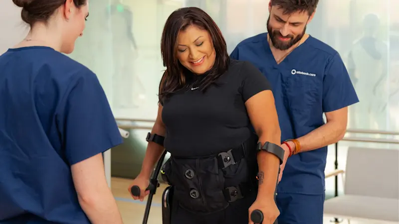 A patient with lower limb difference being assisted while walking in an orthotic clinic