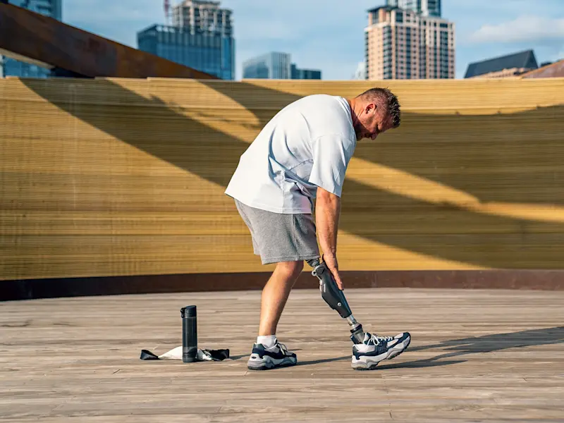 Un usuario de pierna protésica estirando antes de un entrenamiento