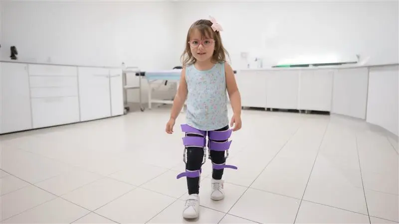 Un paciente pediátrico que realiza entrenamiento de la marcha en un aparato ortopédico personalizado