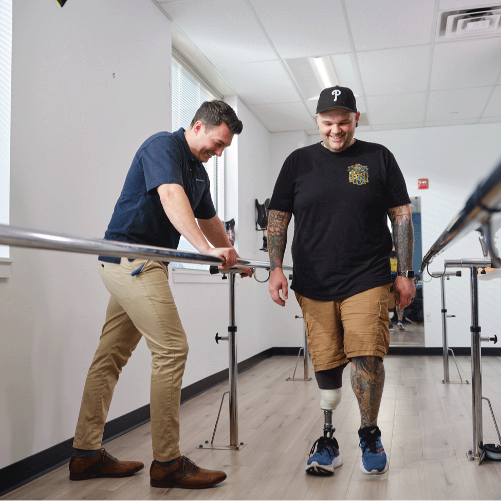 A lower limb prosthetic leg user conducting gait training and a Certified Prosthetist Orthotist