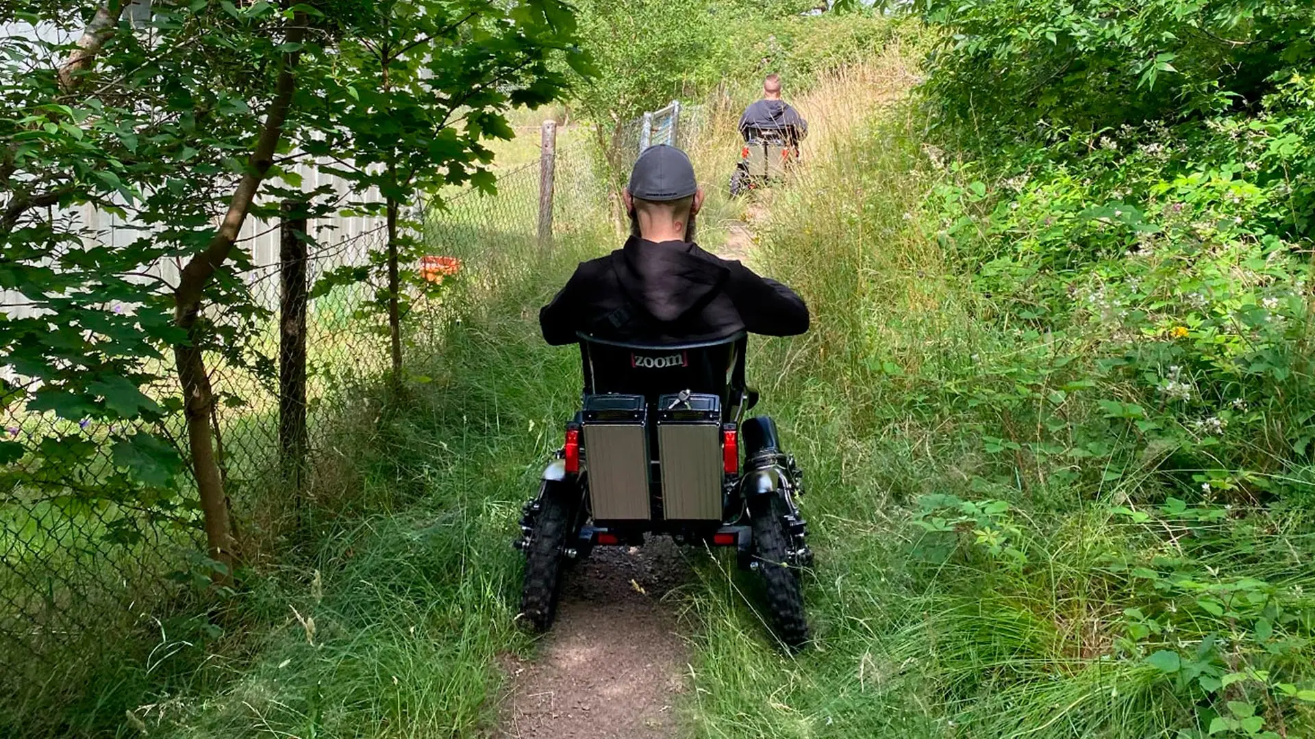Zoom Uphill visto da dietro mentre passa in uno stretto sentiero sterrato