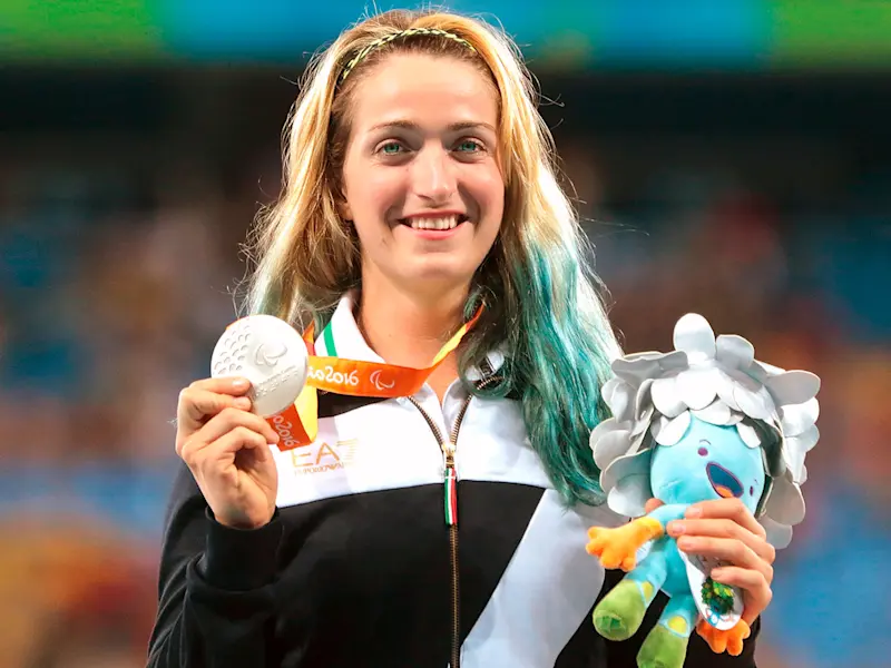 La campionessa olimpica Martina Caironi fotografata sul podio mentre mostra la medaglia