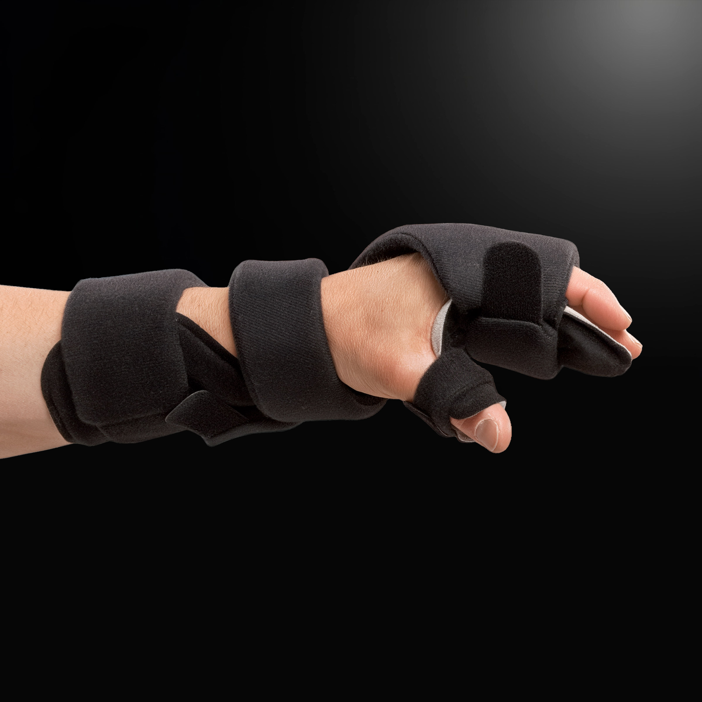 Immagine di un polso che indossa l'ortesi Neuro Soft sotto la luce di una lampada