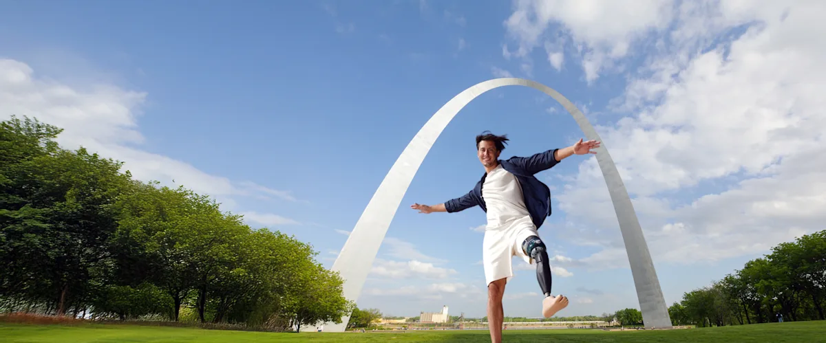 Un usuario de prótesis de la extremidad inferior posando delante del famoso Arco de San Luis