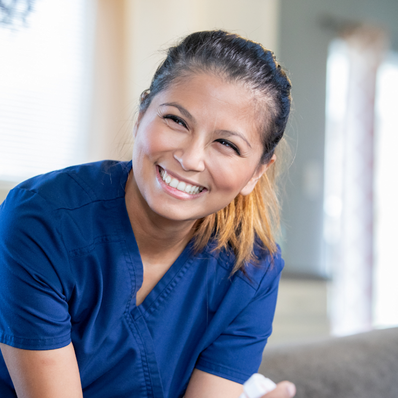 A healthcare employee laughing with a patient