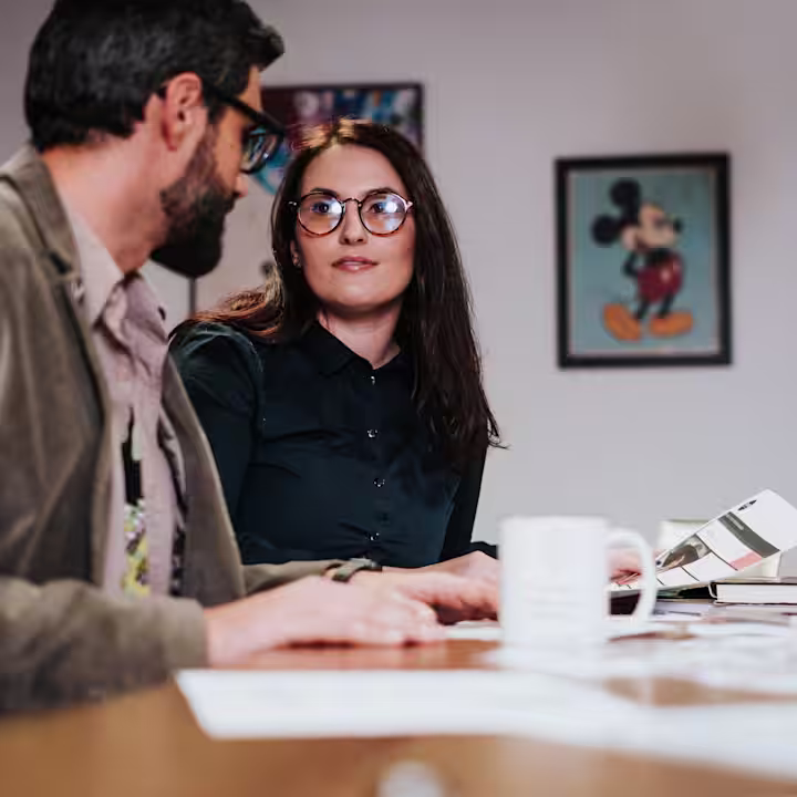 Two co-workers discussing a project in a meeting