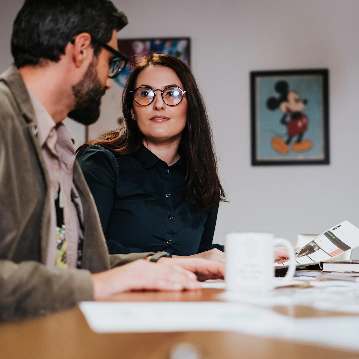Two co-workers discussing a project in a meeting