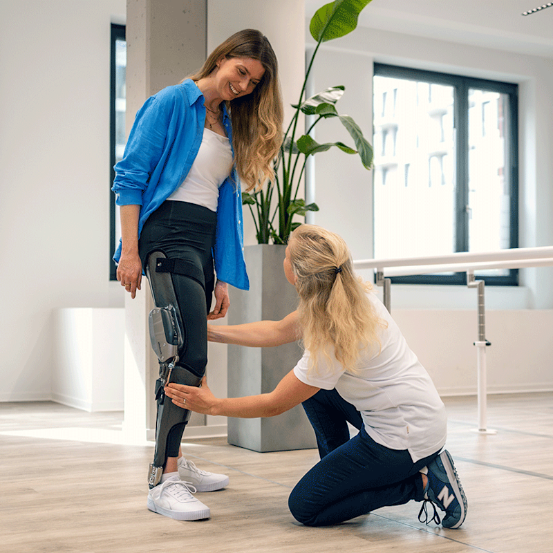Un ortopedista certificado (CO) que coloca una órtesis de rodilla tobillo pie (KAFO) en un paciente