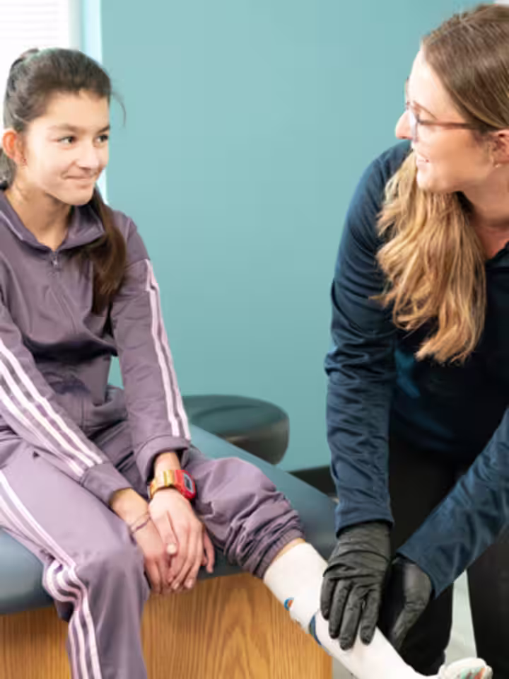 Un ortocista protésico certificado (CPO) que asiste a un usuario de órtesis por debajo de la rodilla