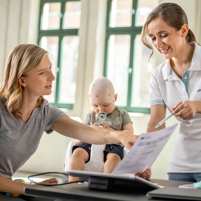 A Certified Prosthetist Orthotist consulting a parent and their child for a pediatric cranial helmet