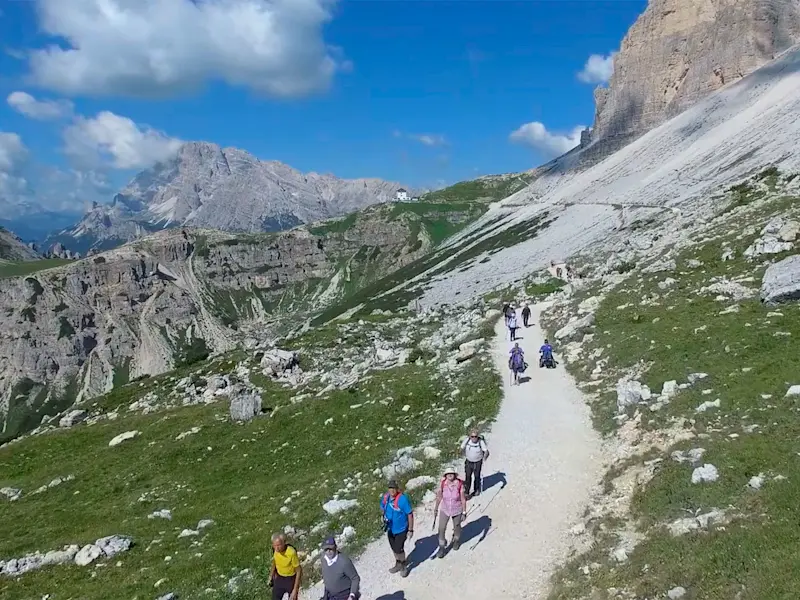 Vista dall'alto di una colonna di escursionisti su un sentiero tra cui due con Zoom Uphill