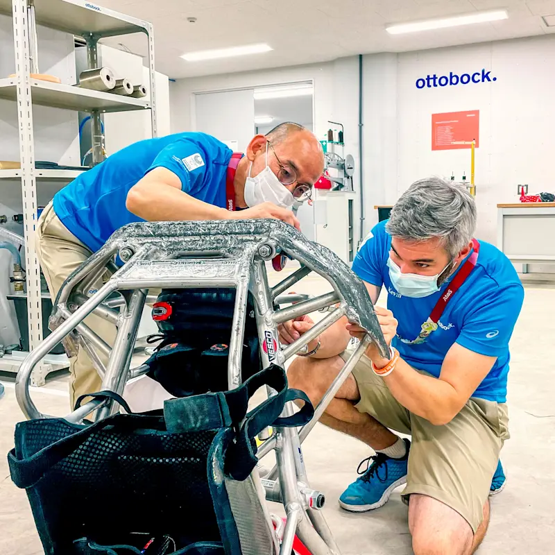 Due tecnici Ottobock.care al lavoro per riparare il telaio di una carrozzina da sport