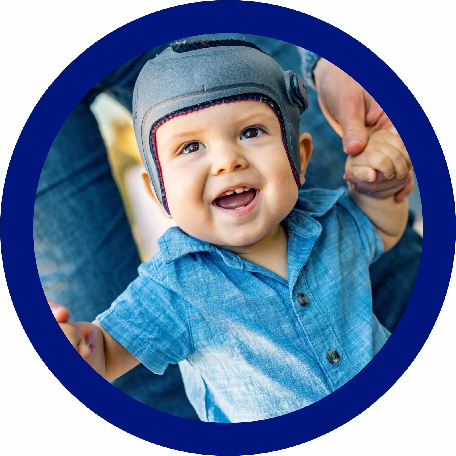 A child wearing a cranial helmet while playing with their parents 