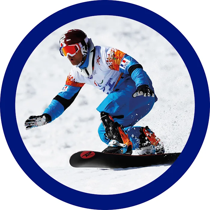 Uno snowboarder con la sua protesi da sport dotata di piede ProCarve scende sulla neve piegato sulla tavola