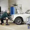 An Nexgear Tango user crouching to work on their vintage car