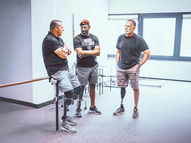 A group of men in prosthetic legs having a discussion in an Ottobock.care clinic